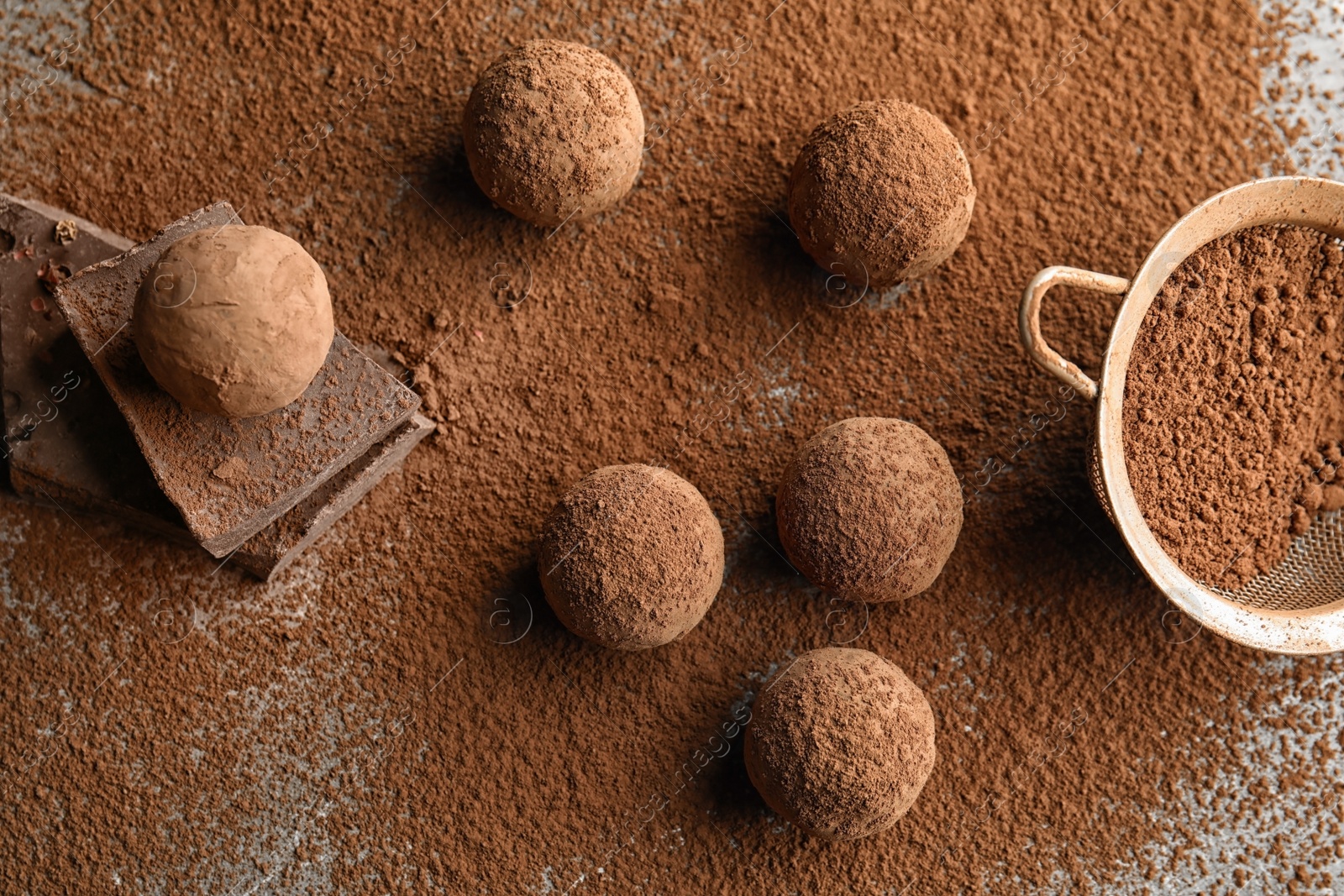 Photo of Flat lay composition with chocolate truffles powdered with cacao on table