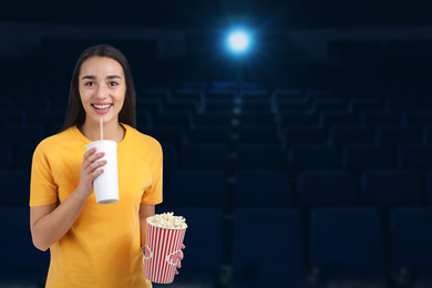 Image of Woman with popcorn and beverage in cinema, space for text