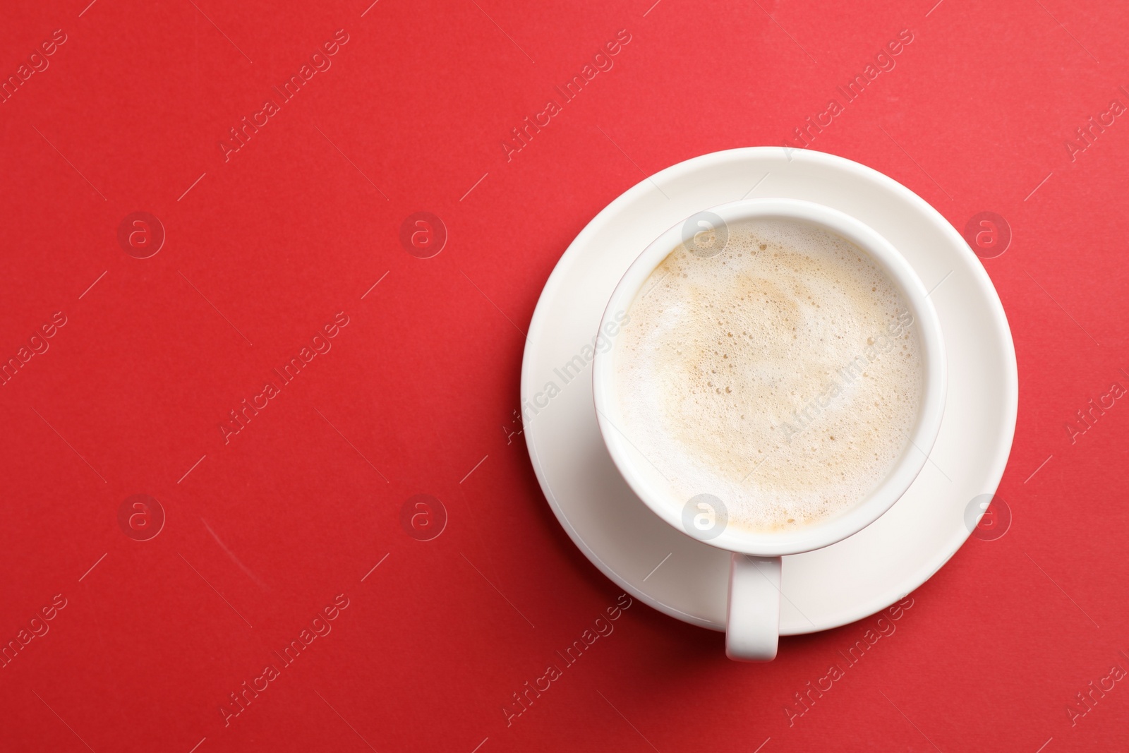 Photo of Cup of aromatic coffee on red background, top view. Space for text