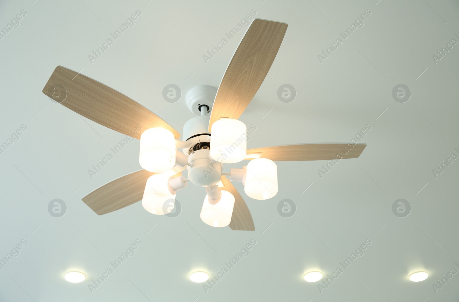 Photo of Ceiling fan with lamps indoors, low angle view