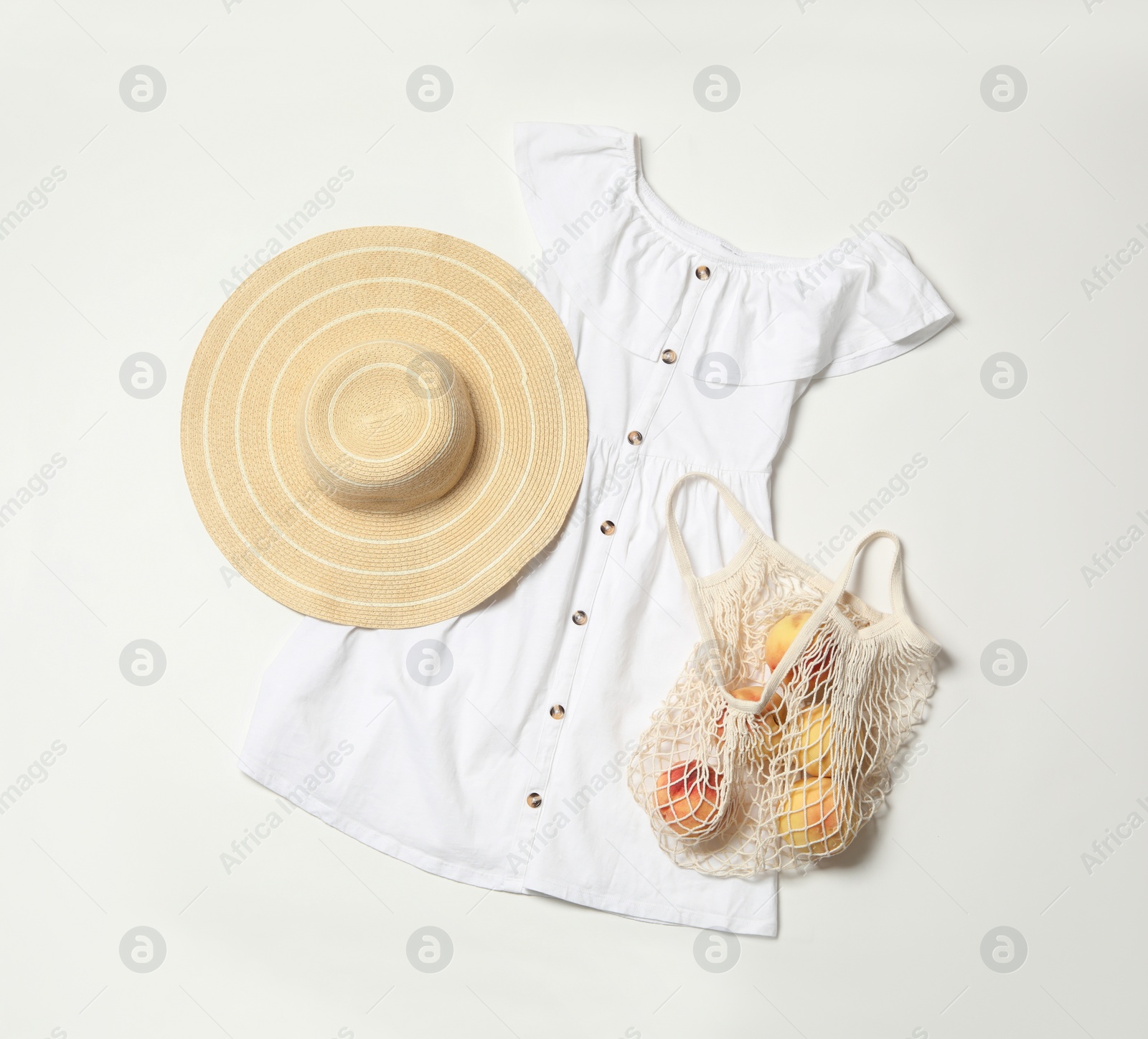 Photo of Stylish dress, hat and peaches on white background, flat lay