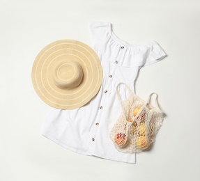 Photo of Stylish dress, hat and peaches on white background, flat lay