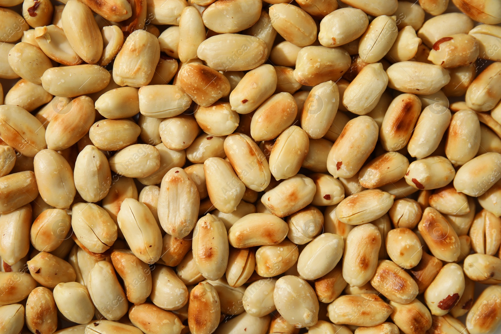 Photo of Many roasted peanuts as background, top view