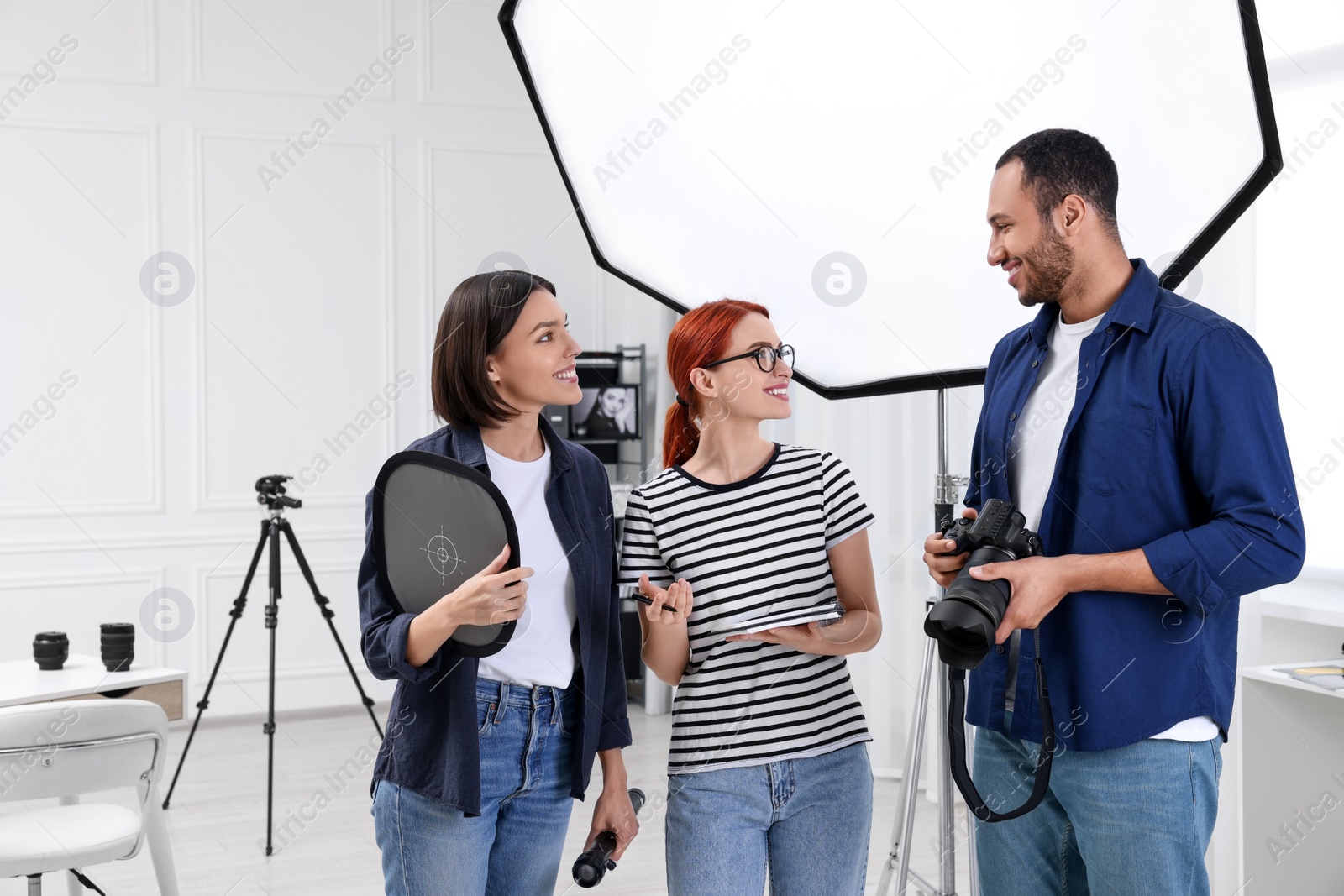 Photo of Young professional photographers working in modern photo studio, space for text