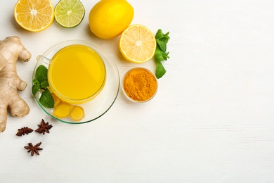 Flat lay composition with immunity boosting drink on white wooden table. Space for text