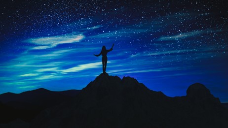 Image of Silhouette of woman in mountains under beautiful starry sky at night, banner design