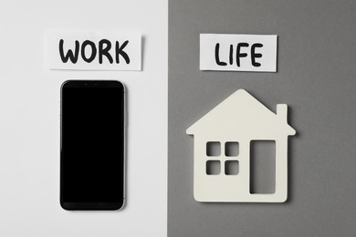 Smartphone and wooden house on color background, flat lay. Life work balance concept