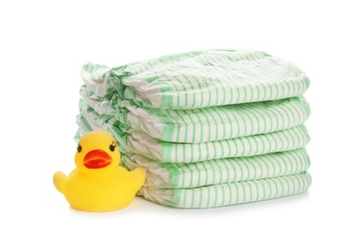 Photo of Stack of disposable diapers and toy duck on white background. Baby accessories