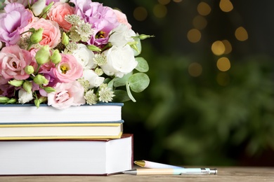 Photo of Composition with flowers and books on wooden table, space for text. Teacher's day