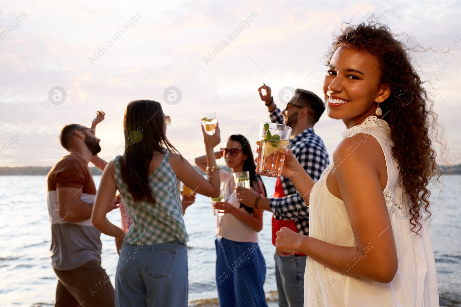 Photo of Woman with friends having fun near river at summer party, space for text