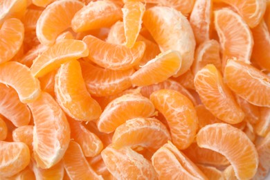 Photo of Segments of tasty tangerines as background, top view