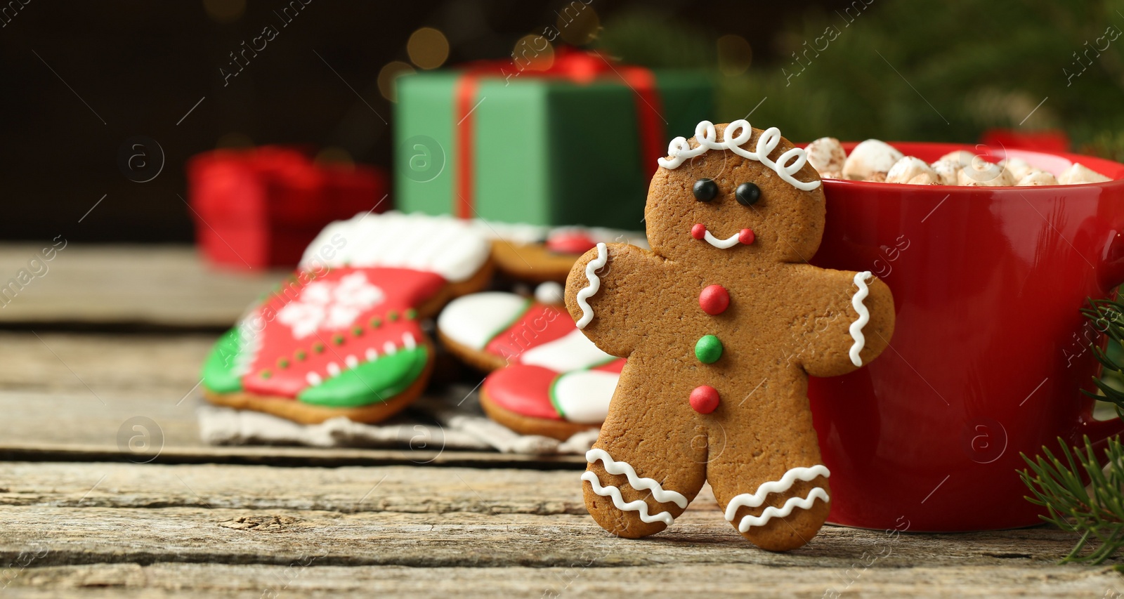 Photo of Tasty gingerbread man cookie and cocoa with marshmallows on wooden table, closeup. Space for text