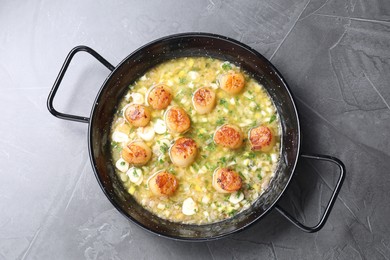 Photo of Fried scallops with sauce in dish on grey table, top view