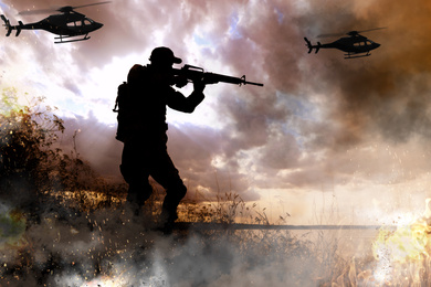 Image of Silhouettes of soldier and helicopters in combat zone. Military service