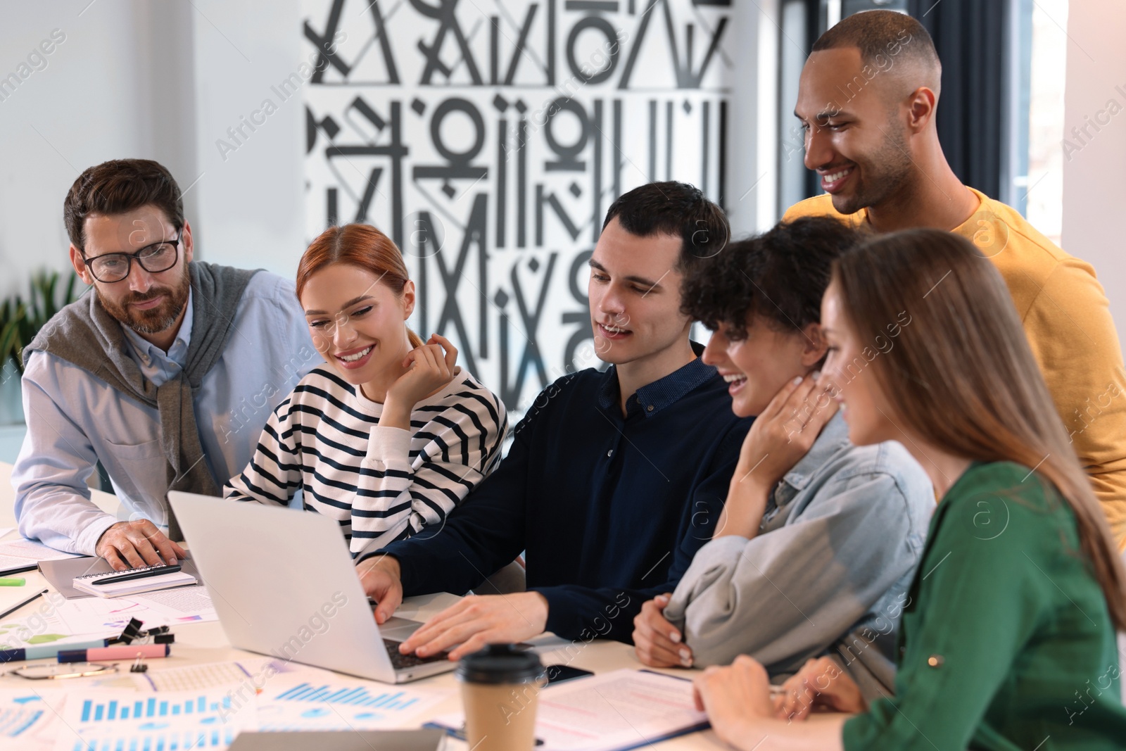 Photo of Team of employees working together at table in office. Startup project