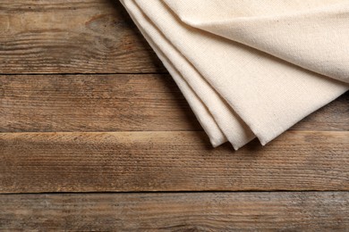 Beige hemp cloth on wooden table, top view. Space for text