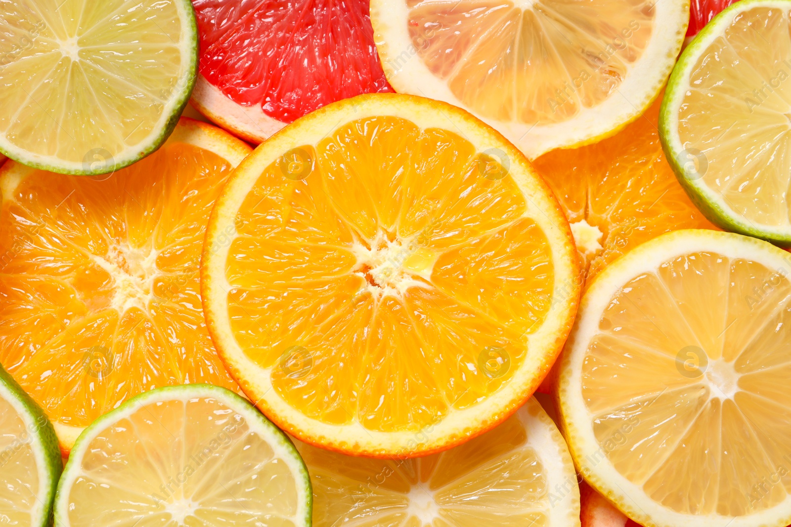 Photo of Different sliced citrus fruits as background, top view