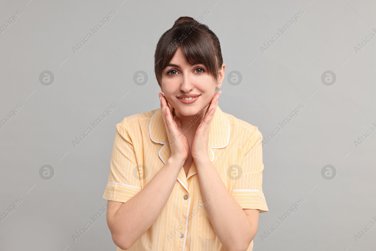 Photo of Happy woman in pyjama on grey background