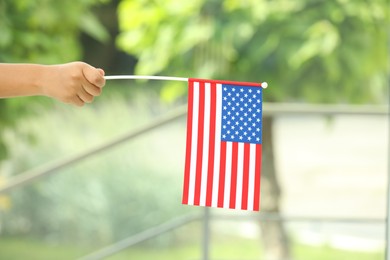 African-American child holding national flag on blurred background, closeup