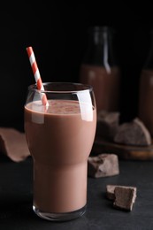 Photo of Delicious chocolate milk in glass on black table