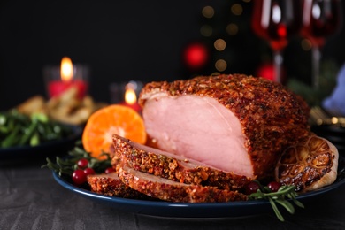 Photo of Plate with homemade Christmas ham on dark table, closeup