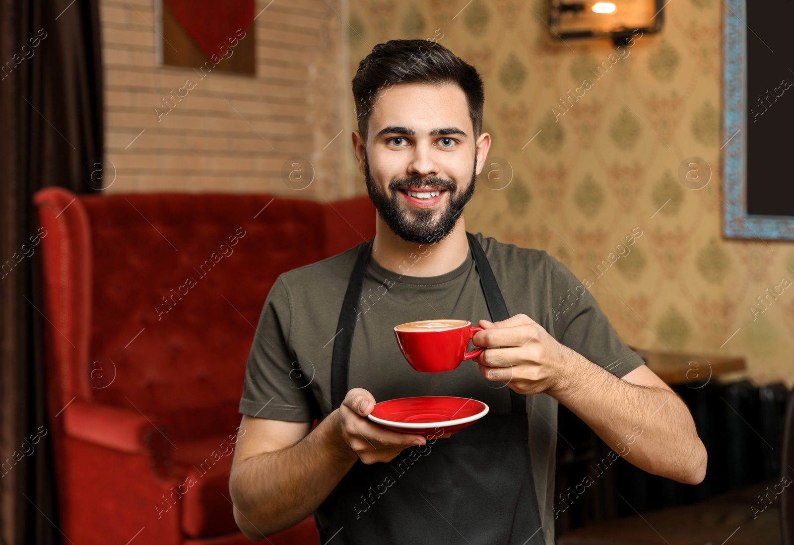 Photo of Portrait of barista with cup of coffee in shop