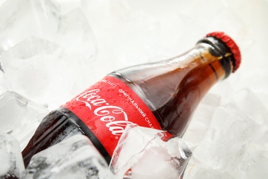 MYKOLAIV, UKRAINE - NOVEMBER 15, 2018: Bottle of Coca Cola on ice cubes, closeup