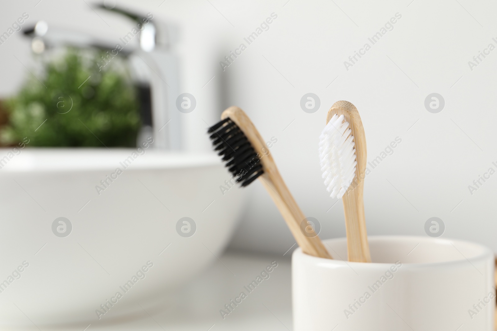 Photo of Bamboo toothbrushes on blurred background, closeup. Space for text