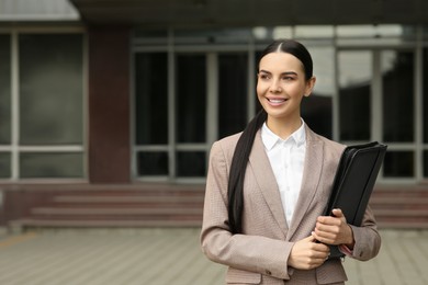 Photo of Beautiful real estate agent with documents outdoors, space for text