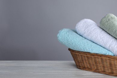 Photo of Fresh towels on wooden table, space for text