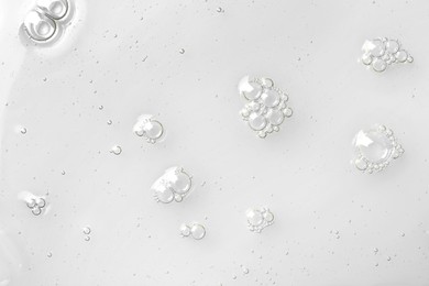 Photo of Hydrophilic oil with bubbles on white background, top view