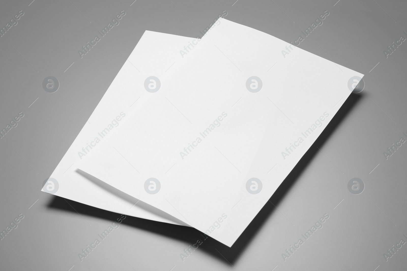 Photo of Blank paper sheets for brochure on grey background. Mock up