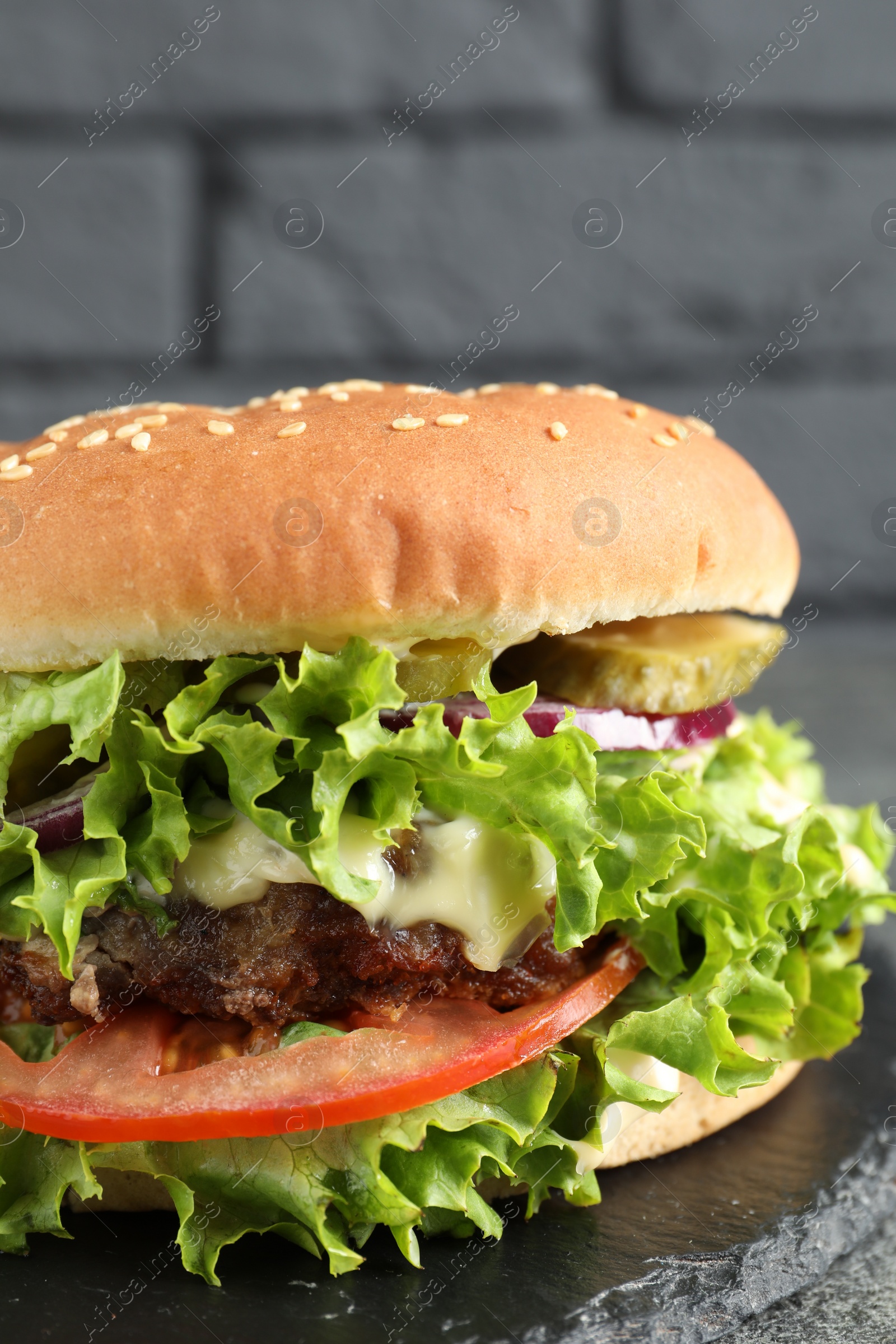 Photo of Delicious burger with beef patty and lettuce on serving board, closeup