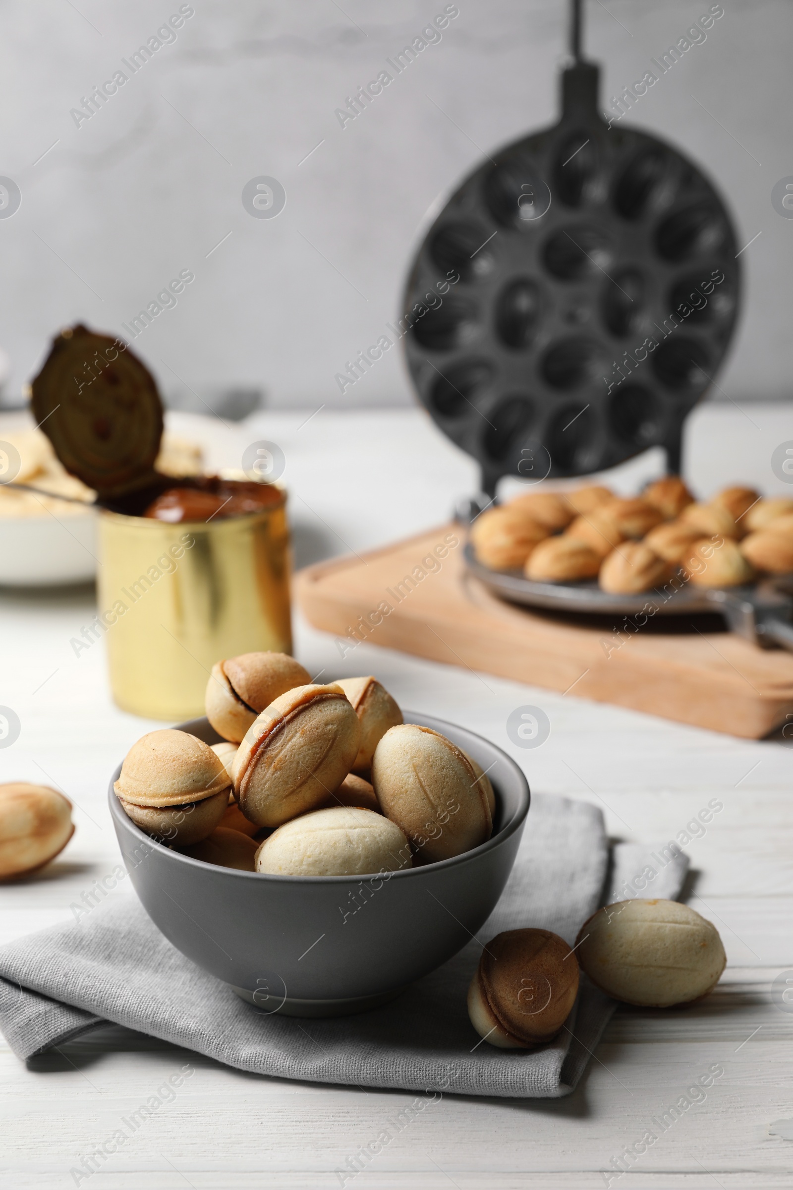 Photo of Delicious walnut shaped cookies with condensed milk on white wooden table