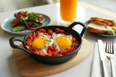 Photo of Tasty Shakshouka served on white table. Traditional Arabic dish