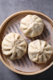 Photo of Delicious bao buns (baozi) on grey textured table, top view