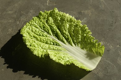 Photo of Fresh Chinese cabbage leaf on gray textured table