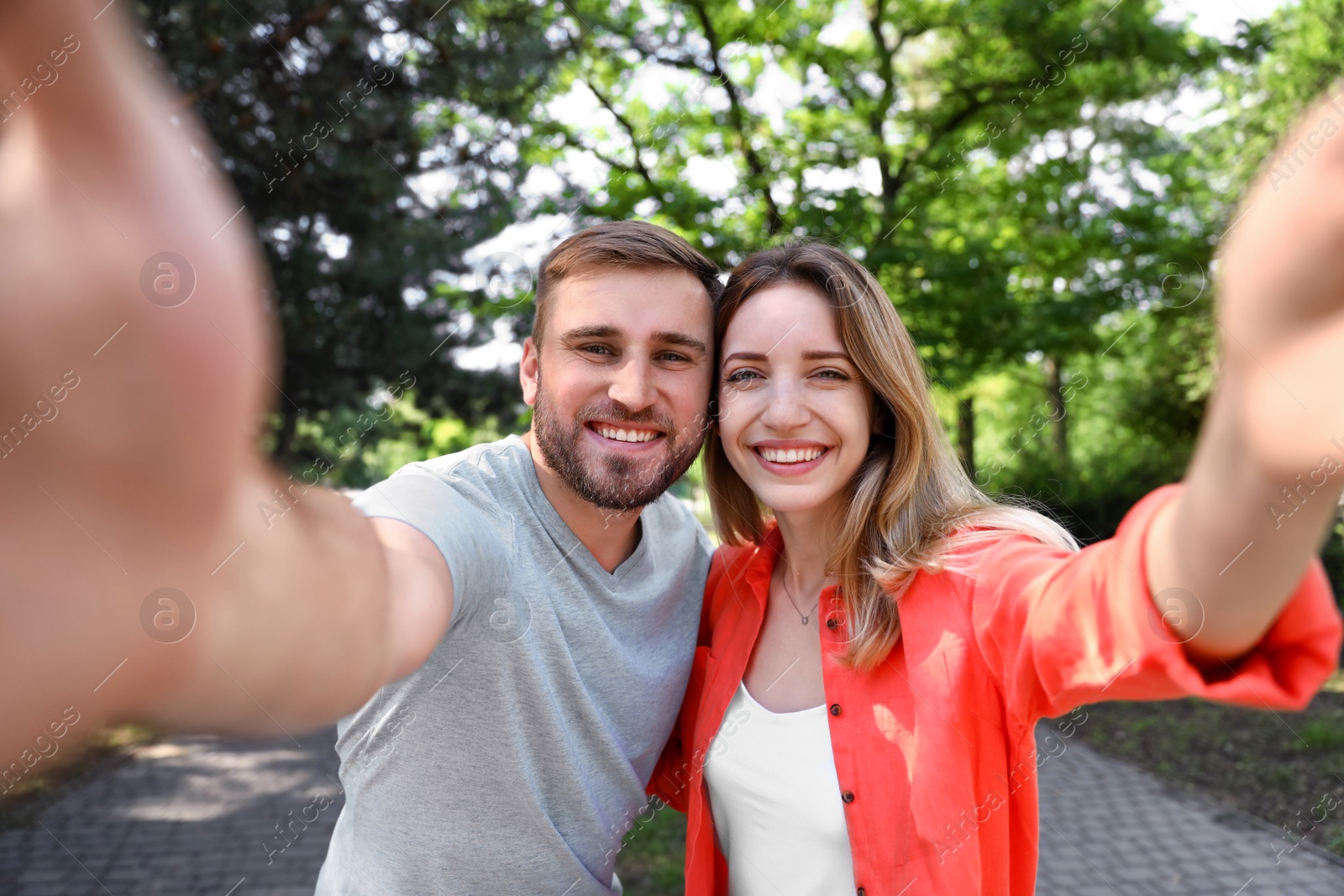 Photo of Happy young couple taking selfie in park