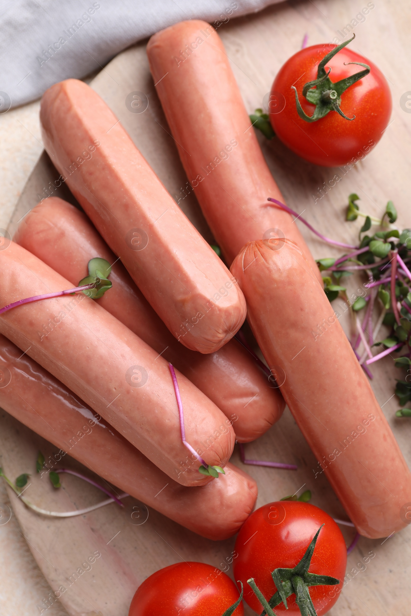 Photo of Tasty vegan sausages and products on wooden board, flat lay