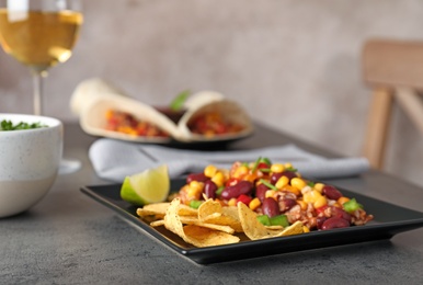 Photo of Plate with tasty chili con carne served on gray table