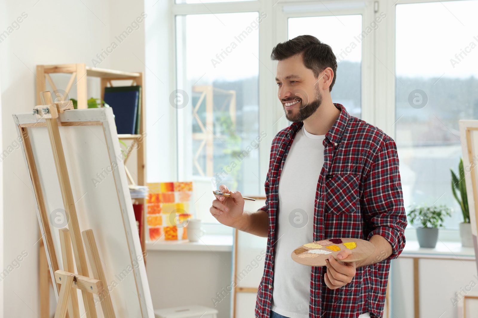 Photo of Handsome man painting in studio. Creative hobby