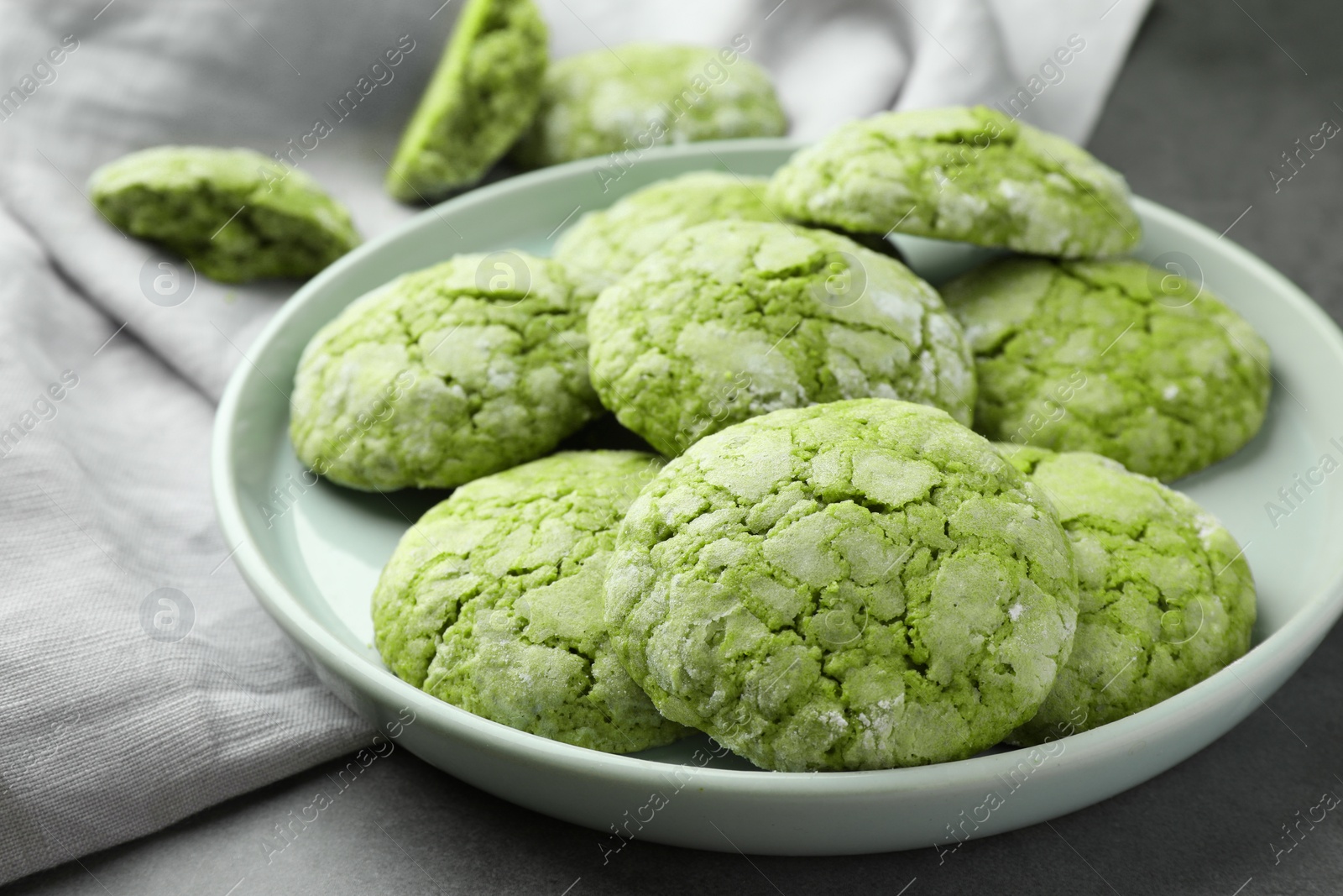 Photo of Plate with tasty matcha cookies on grey table, closeup