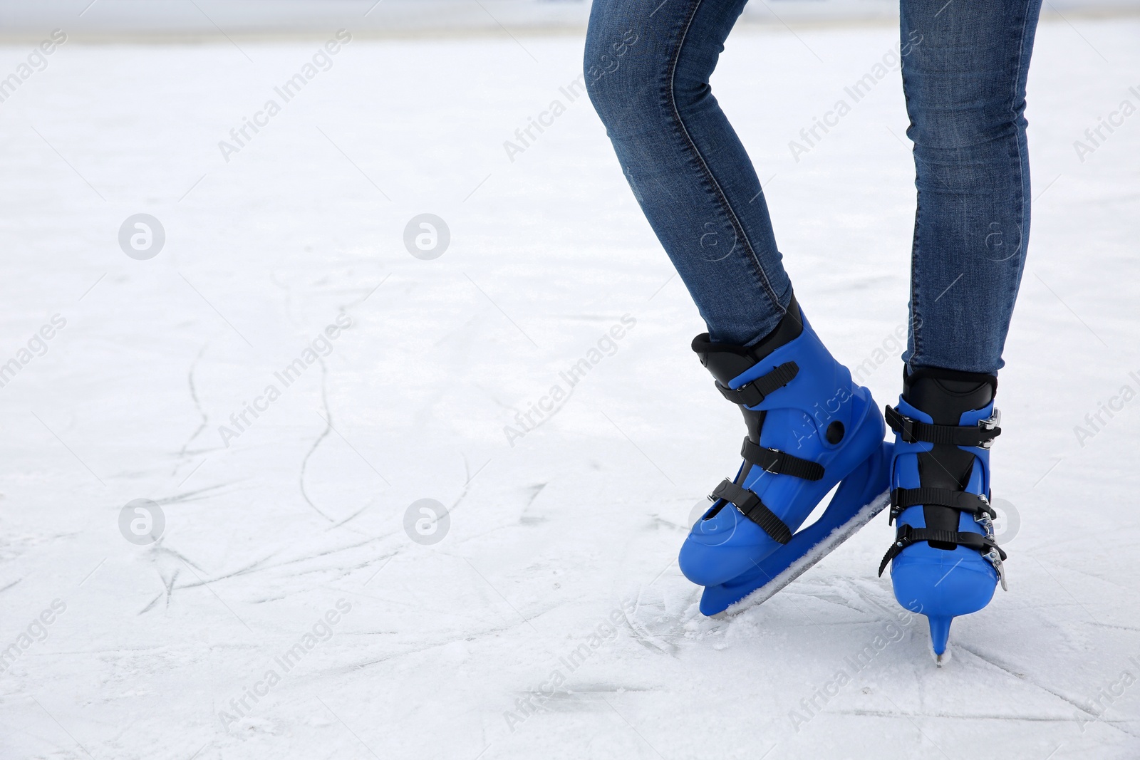 Photo of Woman wearing figure skates on ice rink, closeup. Space for text