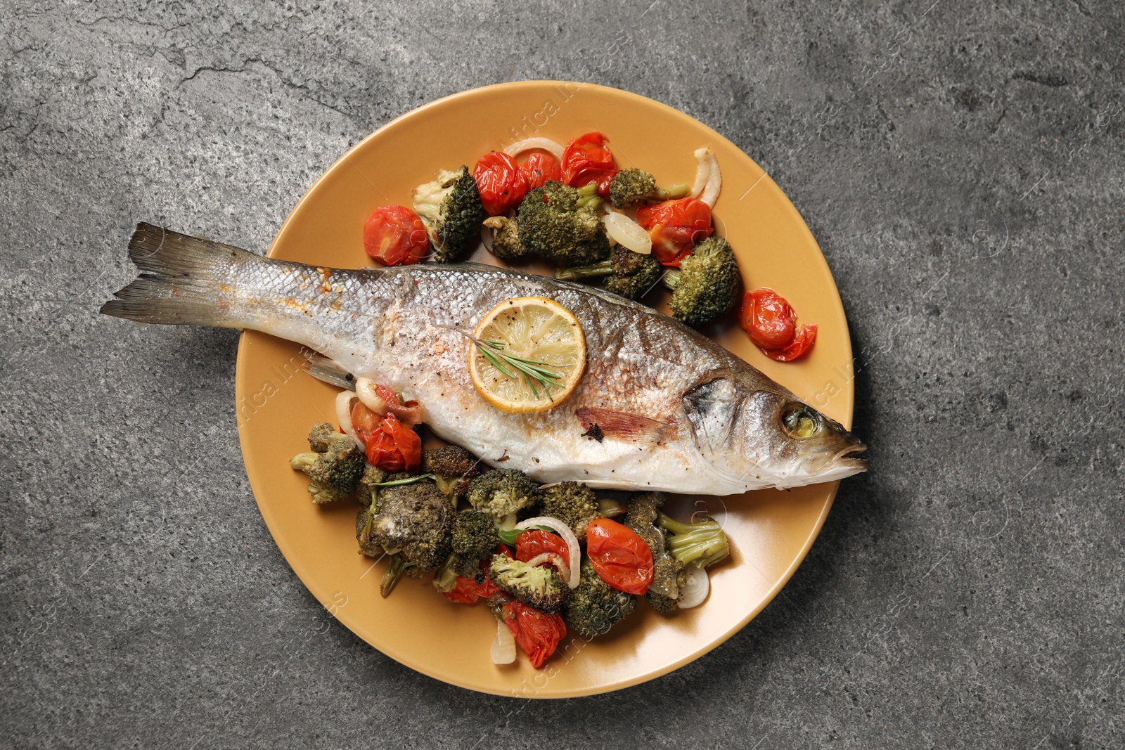 Photo of Delicious baked fish and vegetables on grey background, top view