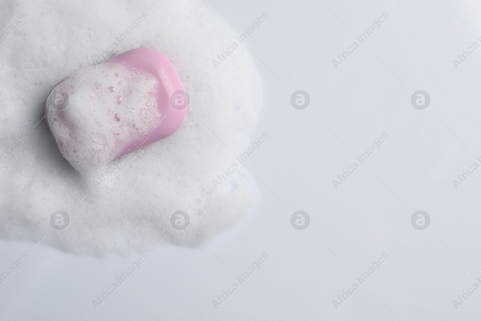 Photo of Soap and fluffy foam on white background, top view