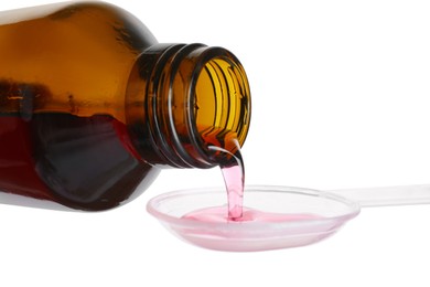 Pouring cough syrup into dosing spoon on white background