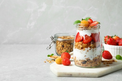 Tasty homemade granola dessert served on grey table, space for text. Healthy breakfast