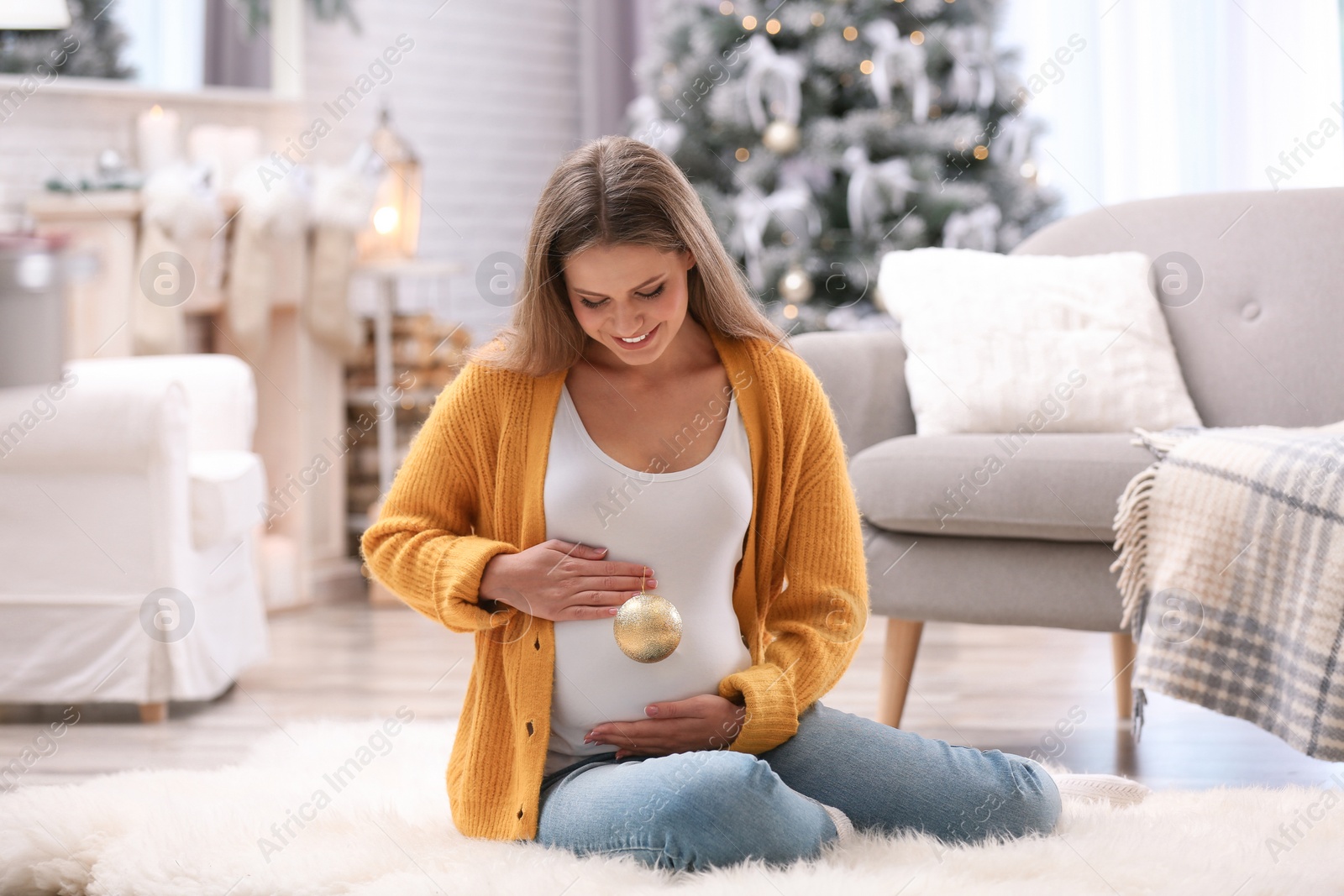 Photo of Young pregnant woman with Christmas decoration at home