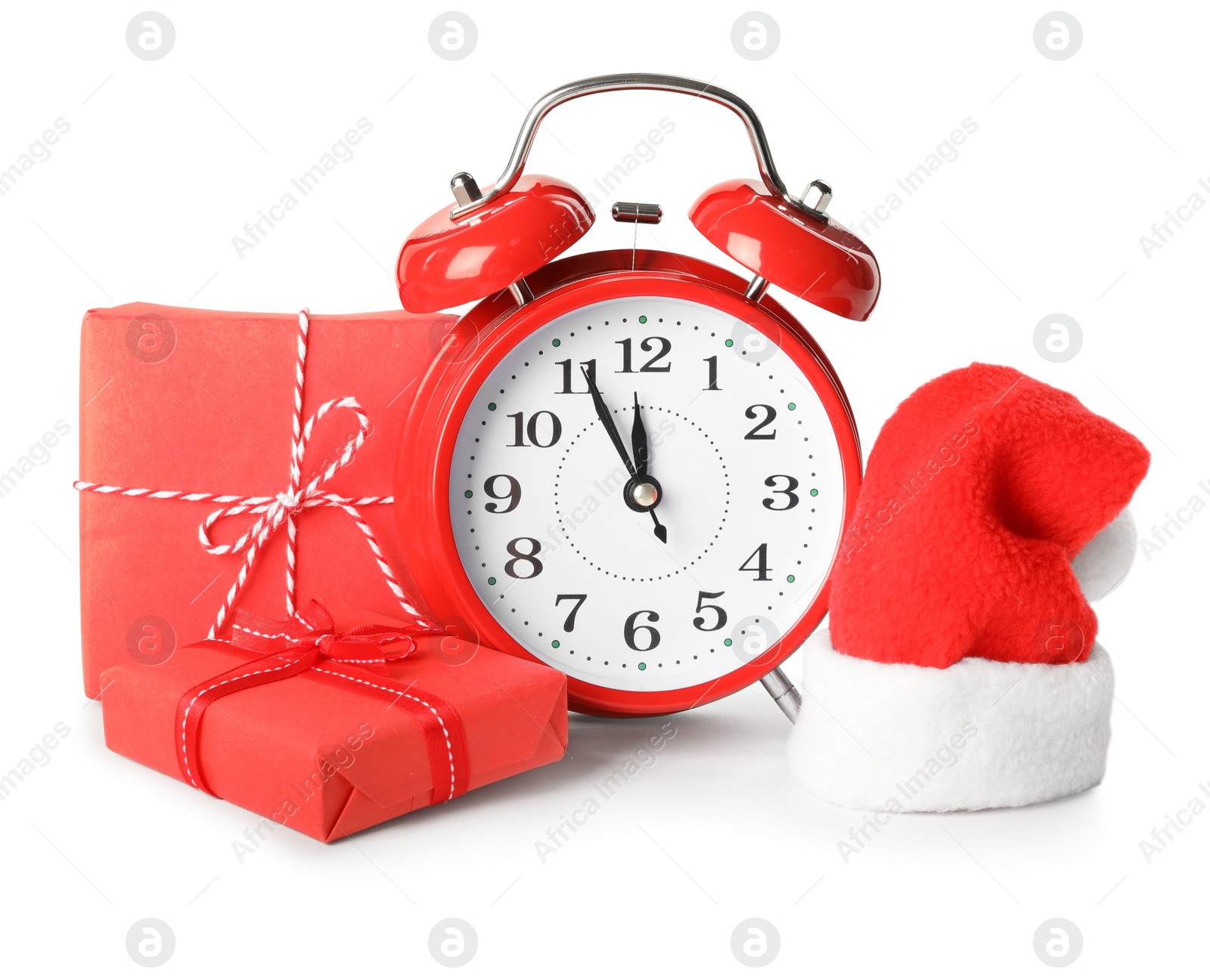 Photo of Alarm clock, gifts and Santa hat on white background. New Year countdown