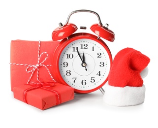 Photo of Alarm clock, gifts and Santa hat on white background. New Year countdown